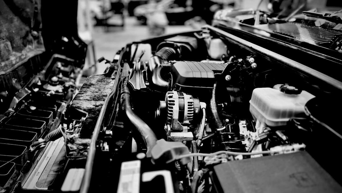 A mobile mechanic inspects the engine under an open hood, preparing tools and equipment for quick, reliable on-site vehicle repair.