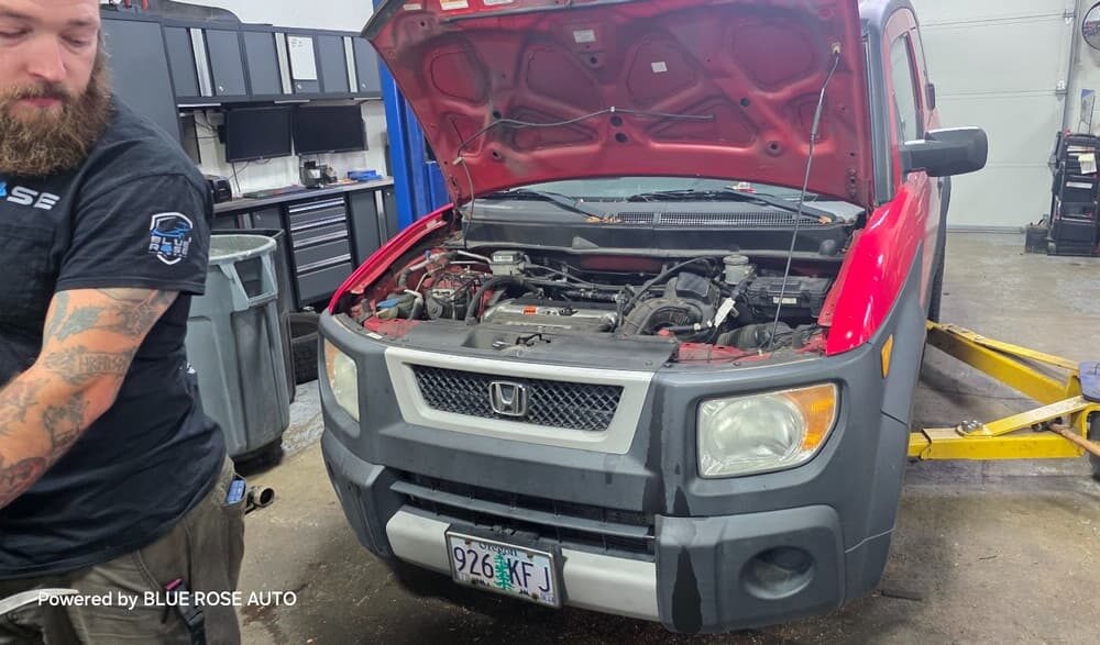 A mobile mechanic pushes his tool cart toward a vehicle with an open hood, ready to perform on-site repairs efficiently.