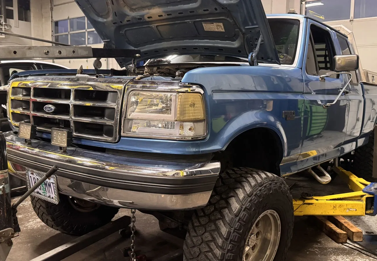 Full-size pickup raised on a lift in the Blue Rose Auto shop in Springfield, Oregon