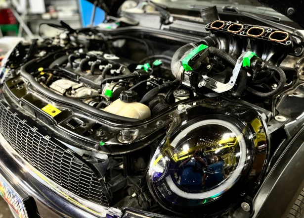 Inline engine in a Springfield, OR shop bay with the intake manifold lifted off and open intake ports showing
