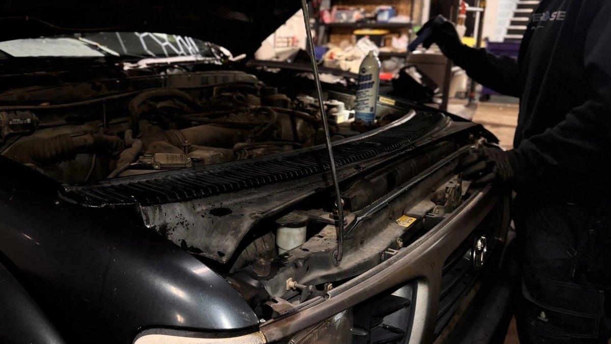 Technician checking fluids under the hood during an engine diagnosis at Blue Rose Auto in Springfield, Oregon