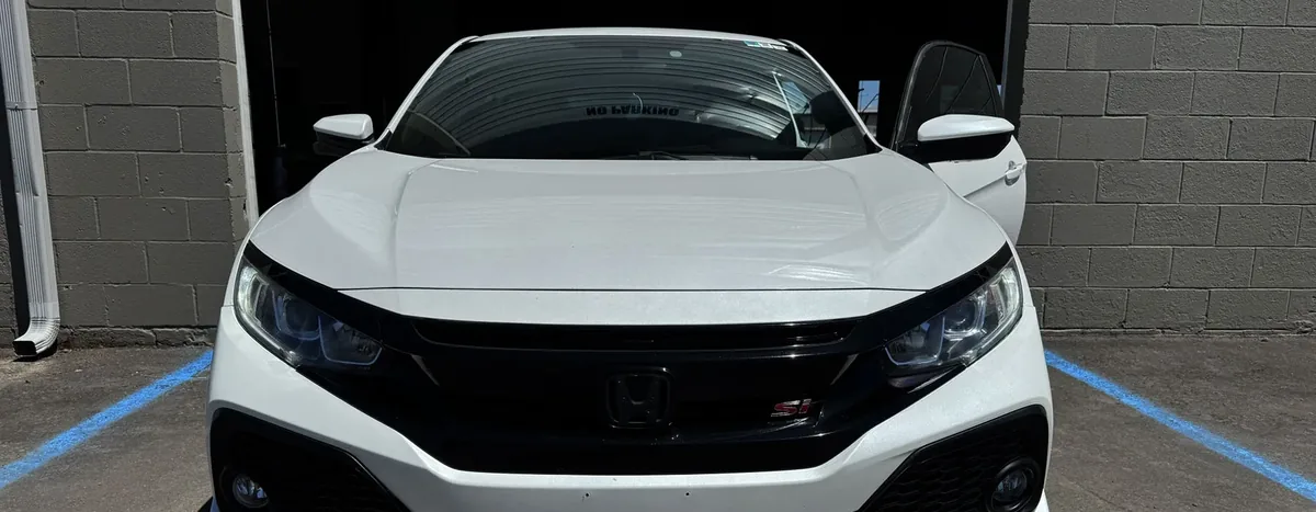 White Honda Civic Si with tinted glass outside our Springfield tint bay