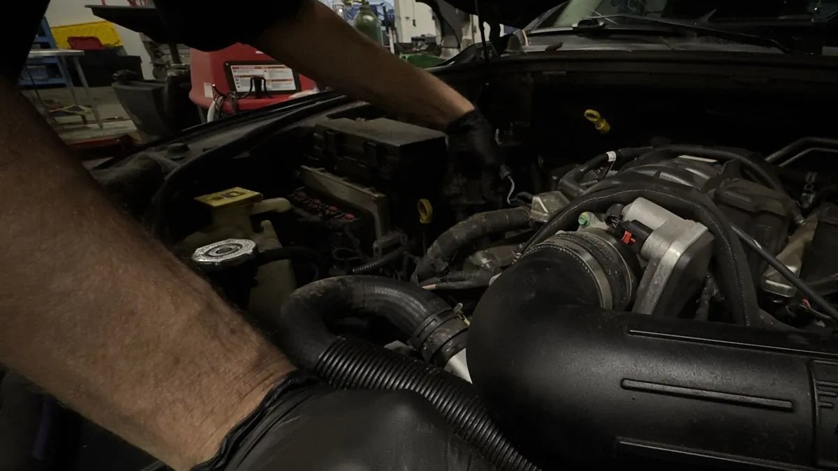 Blue Rose Auto technician in black gloves working in an engine bay at the Springfield shop
