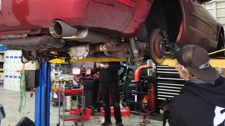 Blue Rose Auto technician checking a wheel hub and brake rotor with the wheel off on a lift in Springfield, OR