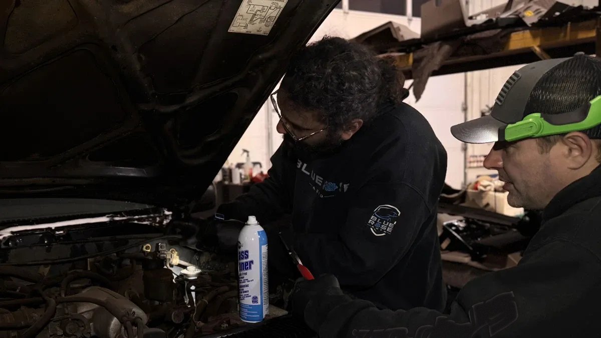 Two Blue Rose Auto technicians checking under the hood of a pickup in the Springfield, OR shop