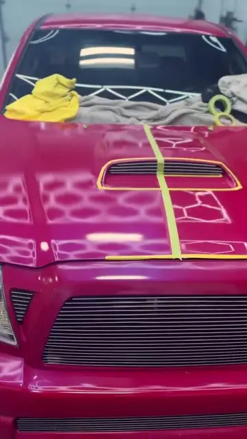 Sanding failed paint off a red Toyota